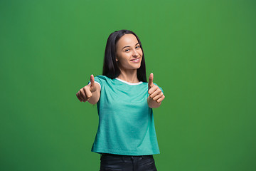 Image showing The happy business woman standing and smiling against green background.