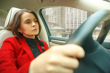 Image showing Driving around city. Young attractive woman driving a car