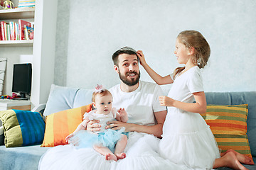 Image showing The happy father and his baby daughters at home