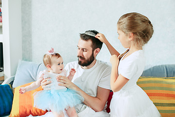 Image showing The happy father and his baby daughters at home