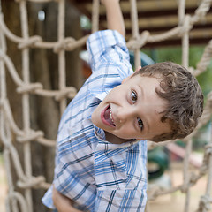 Image showing little boy climbing a rock wall outdoor.