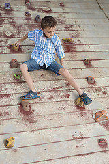 Image showing little boy climbing a rock wall outdoor.