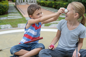 Image showing Happy brother and sister playing mini golf