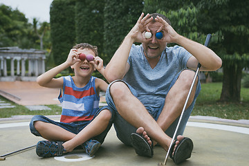 Image showing Happy father and  little son playing mini golf.