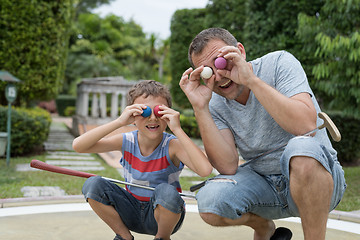 Image showing Happy father and  little son playing mini golf.