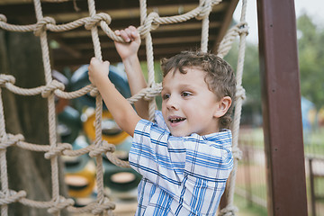 Image showing little boy make climbing in the adventure park.