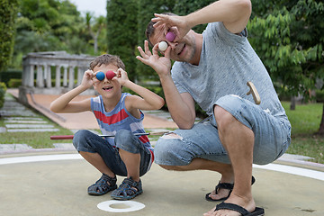 Image showing Happy father and  little son playing mini golf.