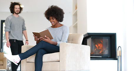 Image showing multiethnic couple hugging in front of fireplace