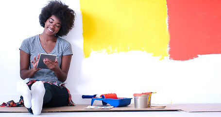 Image showing black female painter sitting on floor