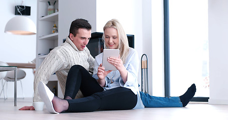 Image showing Young Couple using digital tablet on the floor