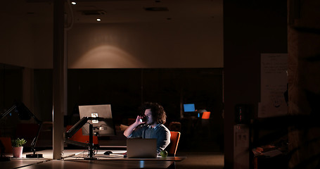 Image showing man working on computer in dark office