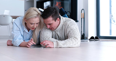 Image showing Young Couple using digital tablet on the floor