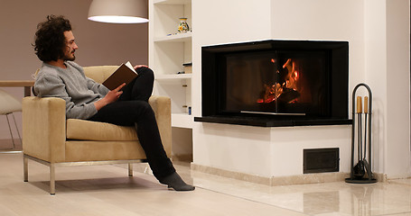 Image showing young man at home reading book