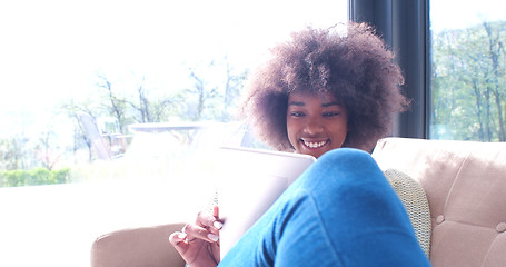 Image showing african american woman at home using digital tablet