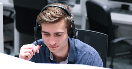 Image showing male call centre operator doing his job