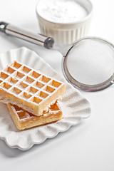 Image showing Belgium waffers with sugar powder on ceramic plate and strainer 