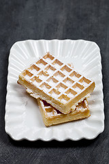 Image showing Belgium waffers with sugar powder on ceramic plateon black board