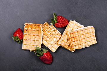Image showing Belgium waffers and strawberries on black board background. 