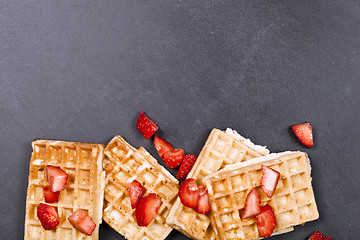 Image showing Belgium waffers and strawberries on black board background. 