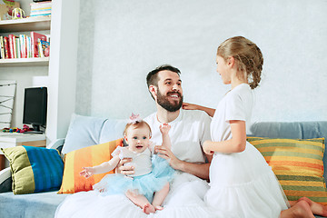 Image showing The happy father and his baby daughters at home