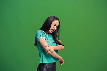 Image showing Young woman overwhelmed with a pain in the elbow