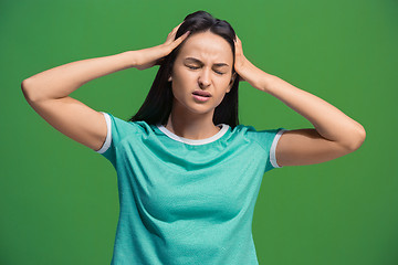 Image showing Woman having headache. Isolated over green background.