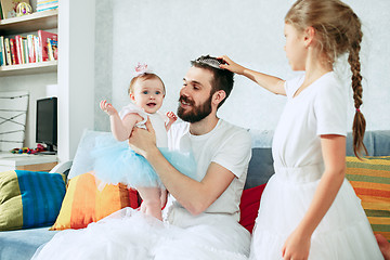 Image showing The happy father and his baby daughters at home