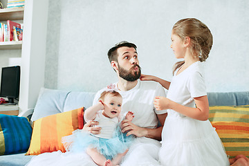 Image showing The happy father and his baby daughters at home