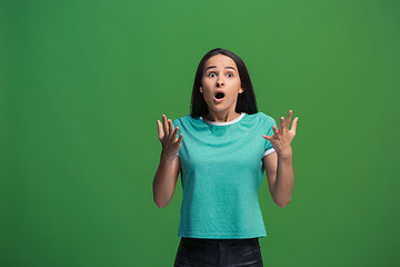 Image showing Beautiful woman looking suprised isolated on green