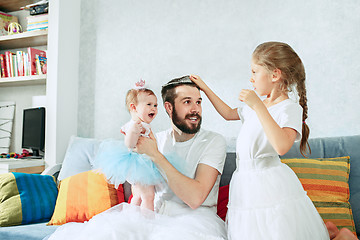 Image showing The happy father and his baby daughters at home