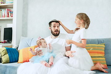 Image showing The happy father and his baby daughters at home