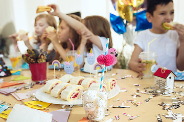 Image showing Girl birthday decorations. table setting with cakes, drinks and party gadgets.