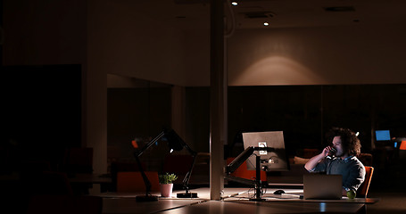 Image showing man working on computer in dark office