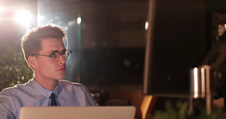 Image showing man working on computer in dark office