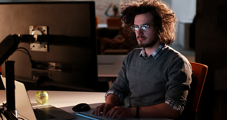 Image showing man working on computer in dark office