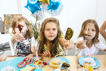 Image showing Girl birthday decorations. table setting with cakes, drinks and party gadgets.