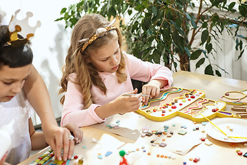 Image showing mosaic puzzle art for kids, children\'s creative game. two sisters are playing mosaic