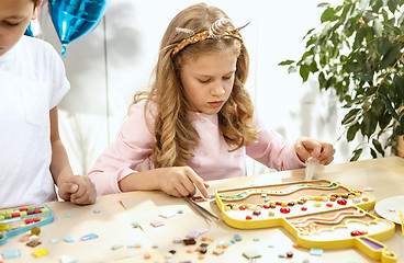 Image showing mosaic puzzle art for kids, children\'s creative game. two sisters are playing mosaic