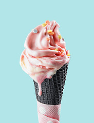 Image showing pink melting ice cream in black waffle cone