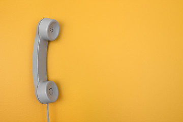 Image showing Classic telephone receiver on bright yellow background