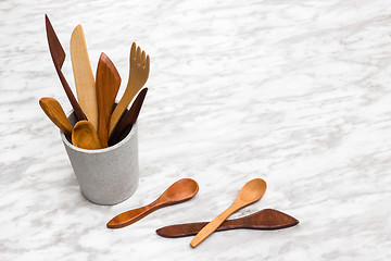 Image showing Handcrafted wooden utensils in a concrete cup