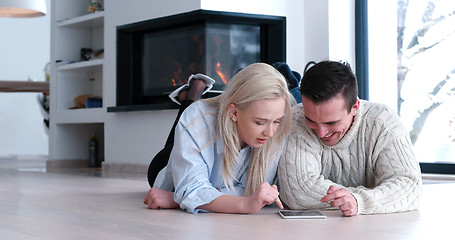 Image showing Young Couple using digital tablet on the floor