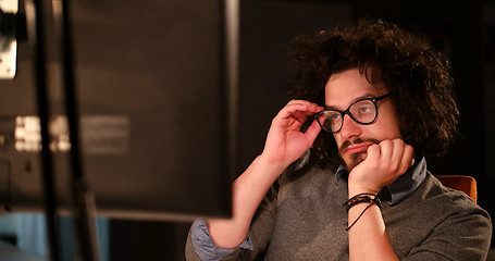 Image showing man working on computer in dark office