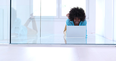 Image showing black women using laptop computer on the floor