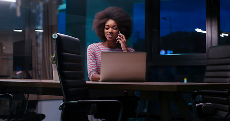 Image showing black businesswoman using a laptop in night startup office