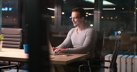 Image showing man working on laptop in dark office