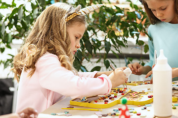 Image showing mosaic puzzle art for kids, children\'s creative game. two sisters are playing mosaic