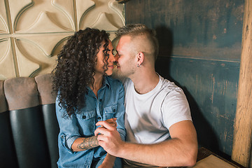 Image showing Happy young couple is drinking coffee and smiling while sitting at the cafe