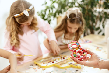 Image showing mosaic puzzle art for kids, children\'s creative game. two girls are playing mosaic