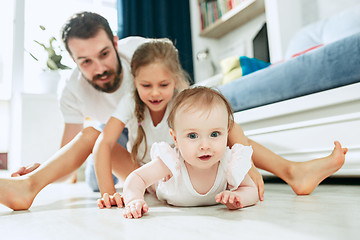 Image showing Proud father holding his newborn baby daughter at home